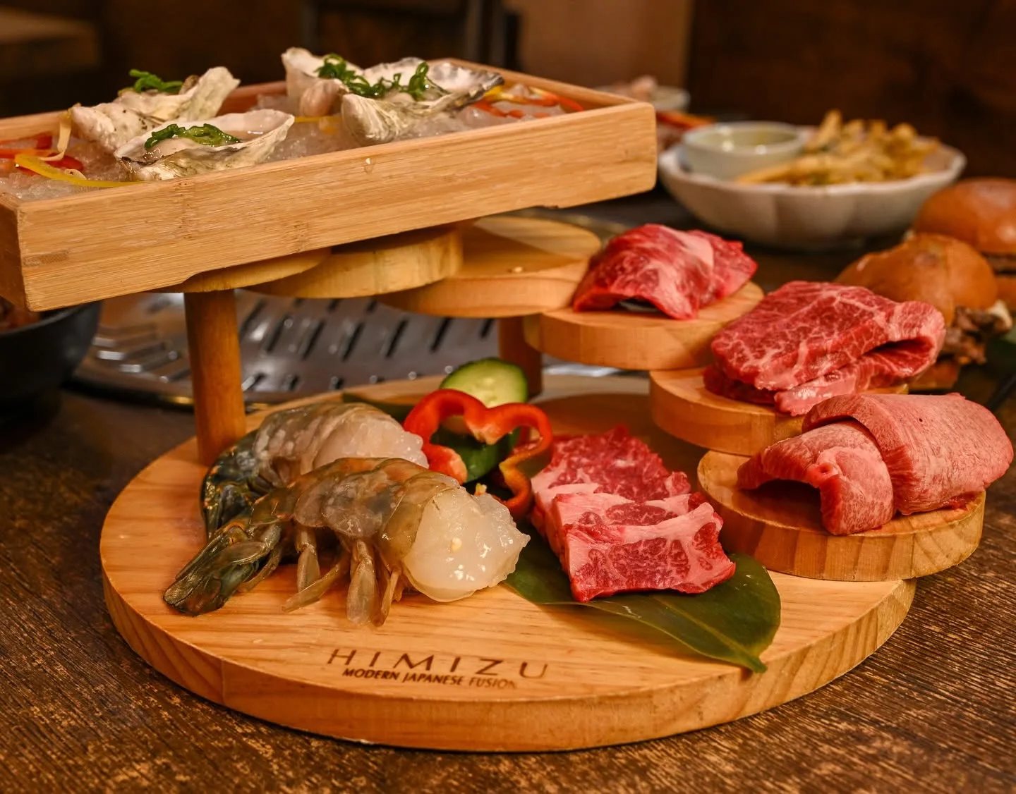 HIMIZU wood platter of raw wagyu cuts, shrimp, and a bamboo steamer